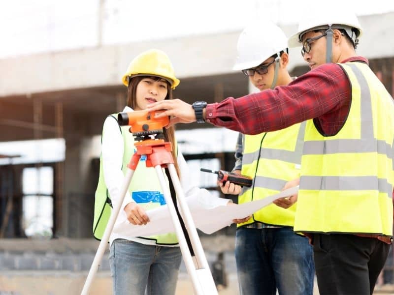 Survey crew reviewing measurements and boundary locations before a residential fence replacement project.