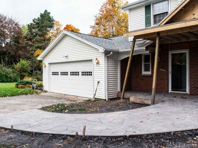 Home addition under construction beside an existing garage in Kansas City Missouri, showing why a lot survey is useful before residential expansion.
